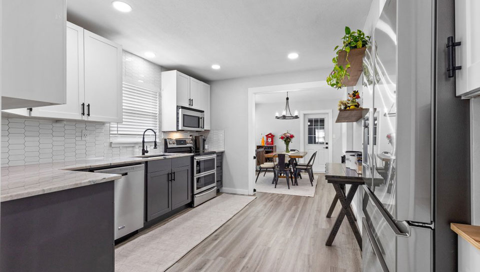 Custom kitchen remodel with dark lower cabinets and entry to dining space