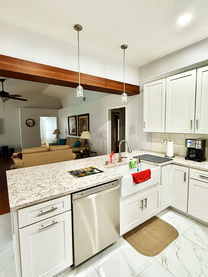 Luxury kitchen remodel with white cabinets and farmhouse sink facing living room